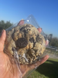 a person holding an oreo cookie in a plastic bag