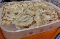 cinnamon rolls in a baking dish with icing on top